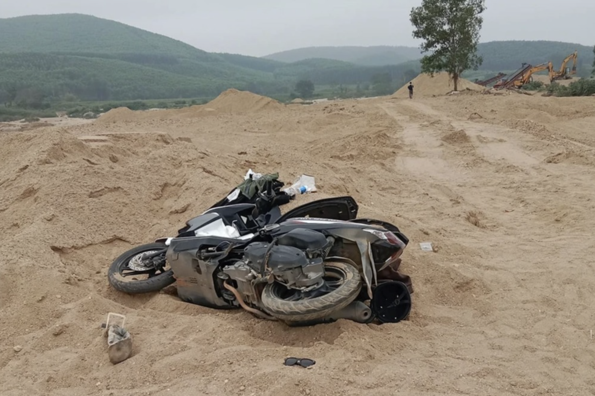 Xe máy và một số đồ dùng cá nhân của nạn nhân trên bãi cát